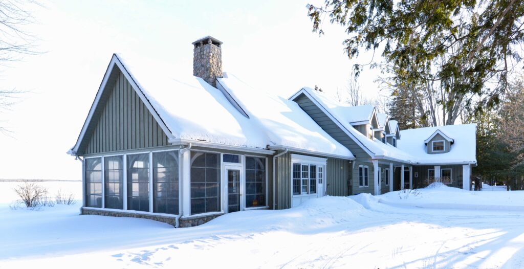Home with enclosed room covered in snow