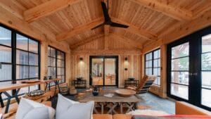 Interior of a cedar Sunspace sunroom with black aluminum frames, vaulted ceiling, and natural light.