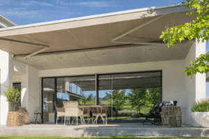 Motorized awning shading glass façade and outdoor seating