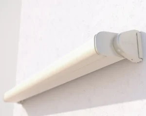 Wall-mounted awning cassette with rounded end cap