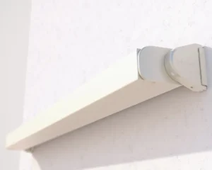 Slim awning housing installed on exterior wall