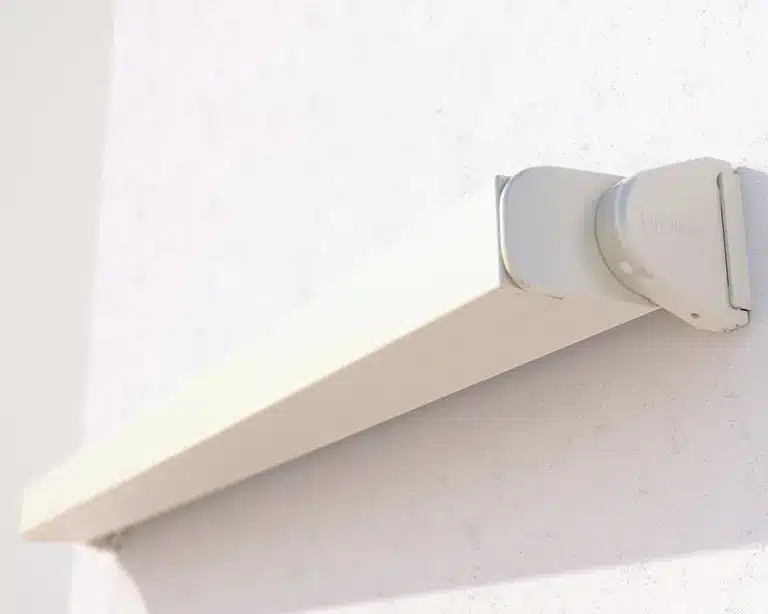 Slim awning housing installed on exterior wall