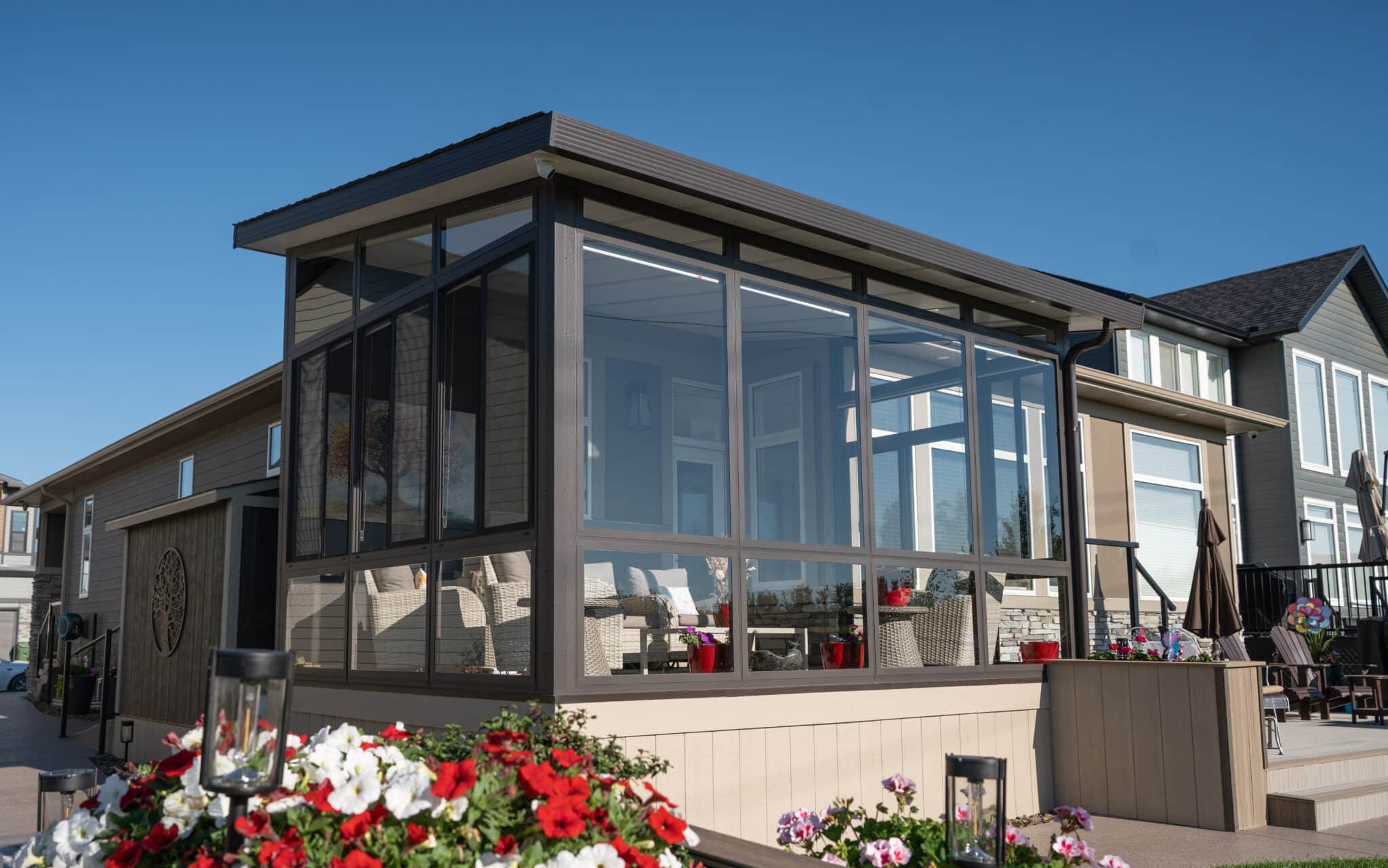 Modern glass sunroom with black aluminum frame and hardtop roof