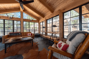 Wood-framed sunroom with vaulted ceiling and wraparound windows