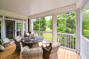 Screened porch with railing and outdoor dining area
