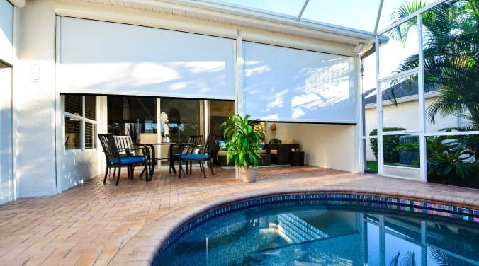 Covered patio with retractable screen and pool view