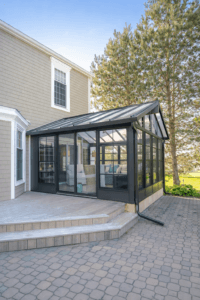 Glass sunroom attached to house with black aluminum frame