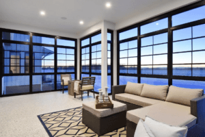 Sunroom with wraparound windows overlooking water and sky