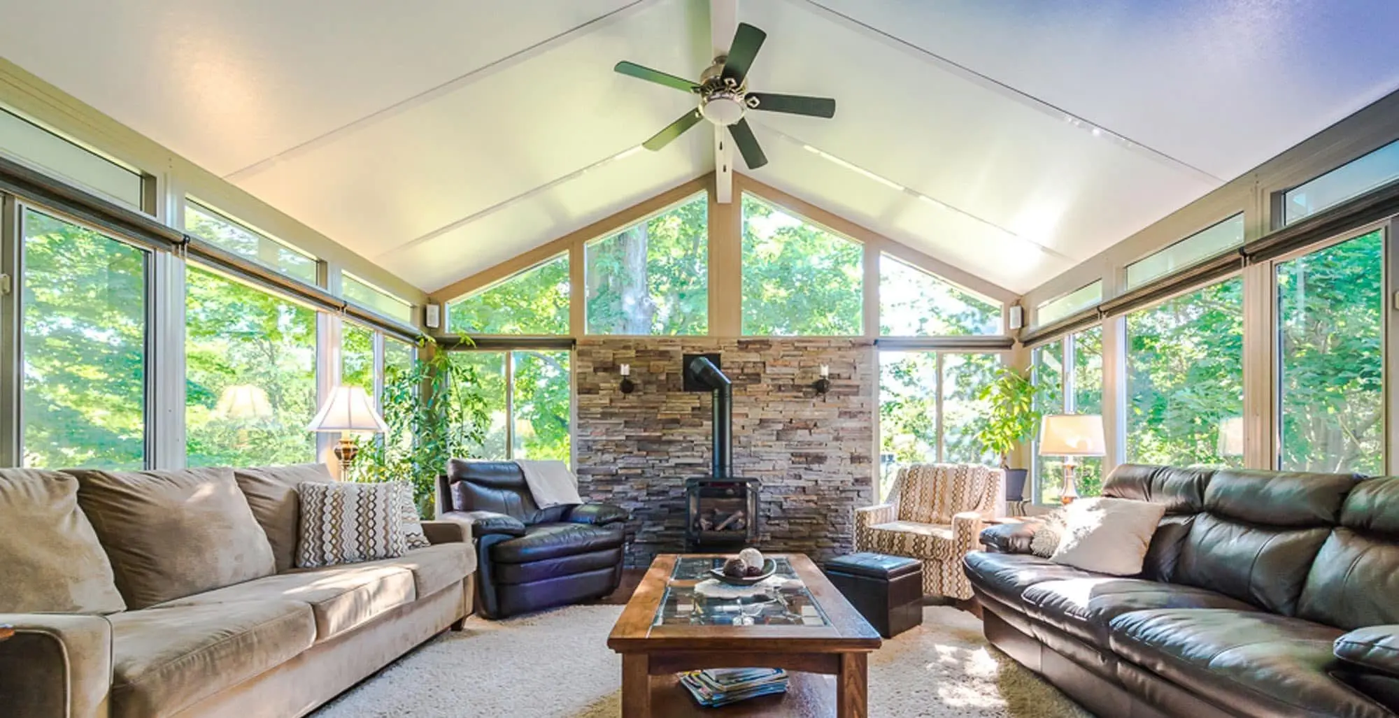 Rustic-modern sunroom with stone wall and cathedral ceiling