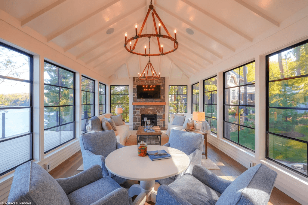 Elegant sunroom with dining table, fireplace, and vaulted ceiling