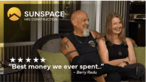 Homeowners smiling while relaxing inside their custom sunroom